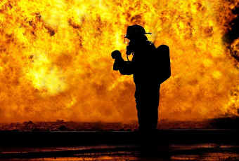 Silhouette of a firefighter in front of a blaze
