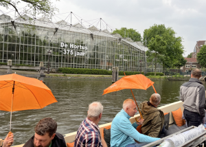 Amsterdam canal boat with large greenhouse in background